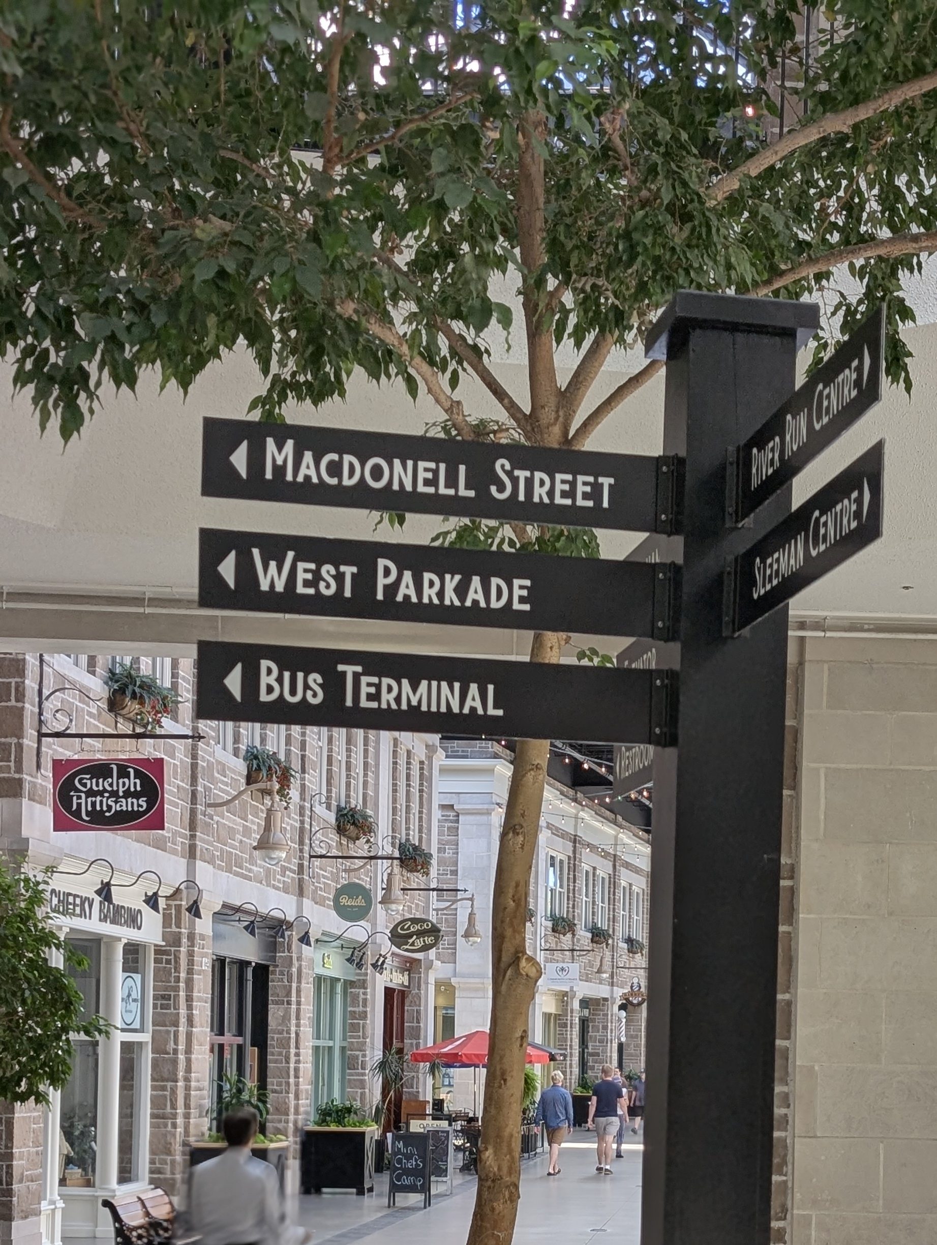 Directional wayfinding signs point the way to Macdonell Street, the Quebec St. Mall West Parkade, and the downtown Guelph Bus terminal.